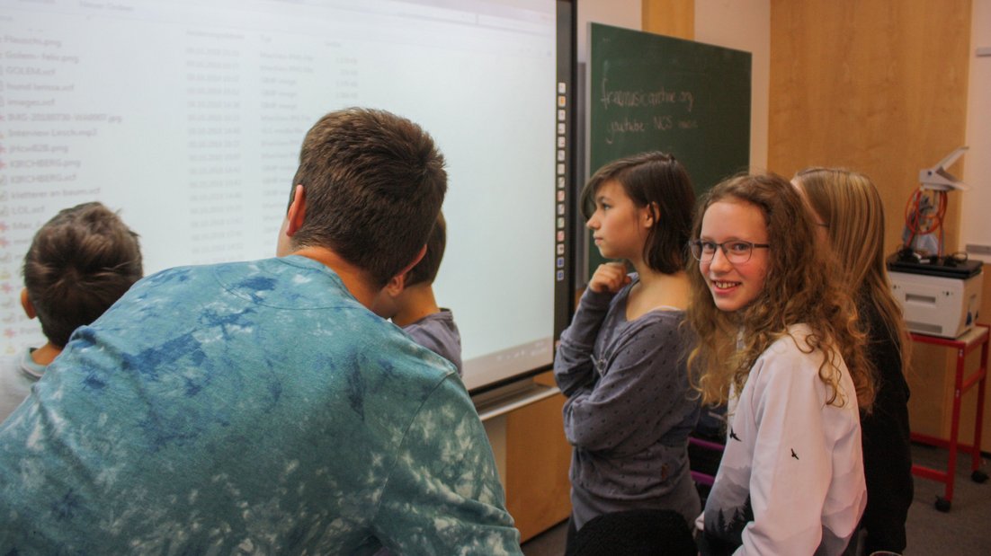 Studenti pregledaju projekciju projektora na beloj tabli