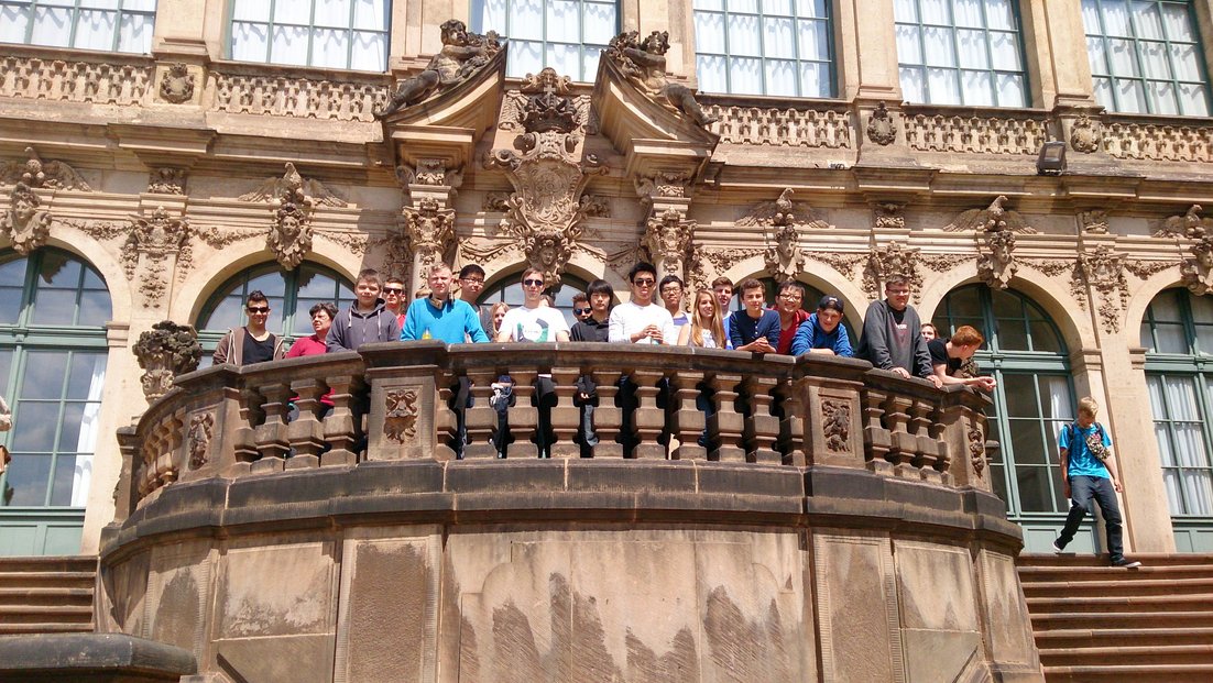 Grupa studenata stoji na balkonu istorijske zgrade.